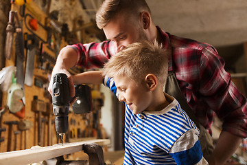 Image showing father and son with drill working at workshop