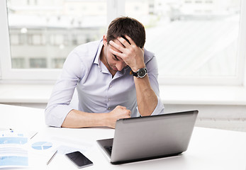 Image showing businessman with laptop and papers in office