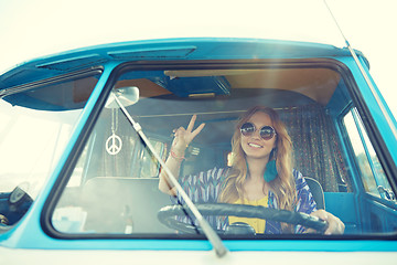 Image showing smiling young hippie woman driving minivan car