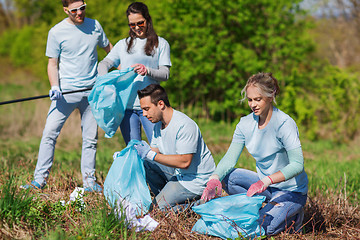 Image showing volunteers with garbage bags cleaning park area