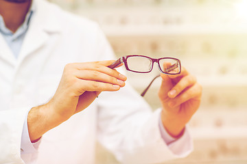 Image showing close up of optician with glasses at optics store