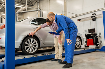 Image showing auto mechanic with clipboard and man at car shop