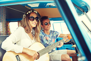 Image showing smiling hippie couple with guitar in minivan car