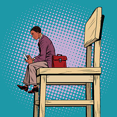 Image showing Small business man on the big chair, and smartphone