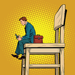 Image showing Small business man on the big chair, and smartphone