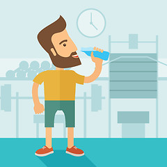 Image showing Gentleman drink a bottle of water while inside the gym.