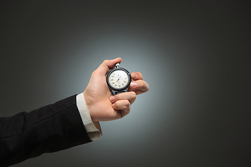 Image showing hand holding a stopwatch against a white background