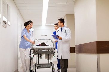 Image showing medics with woman on hospital gurney at emergency