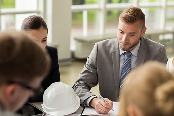 Image showing architects with helmet and clipboard at office