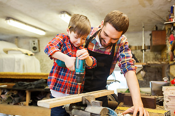 Image showing father and son with drill working at workshop