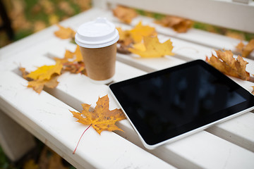 Image showing tablet pc and coffee cup on bench in autumn park