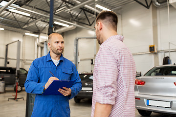 Image showing auto mechanic with clipboard and man at car shop