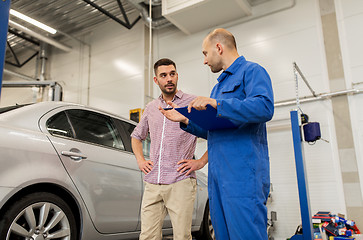 Image showing auto mechanic with clipboard and man at car shop