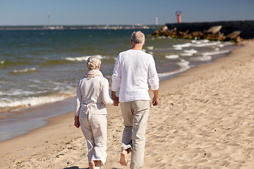 Image showing senior couple walking along summer beach