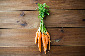 Image showing close up of carrot bunch on wooden table