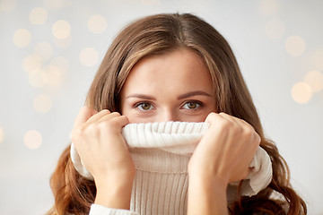 Image showing young woman or teen girl pulling pullover collar