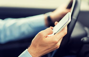 Image showing close up of man hand with smartphone driving car