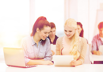 Image showing two smiling students with laptop and tablet pc