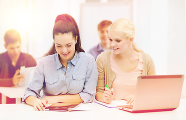 Image showing two smiling students with laptop and tablet pc