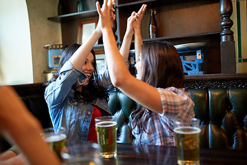 Image showing happy friends with beer celebrating at bar or pub