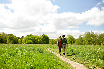 Image showing happy couple with backpacks hiking outdoors