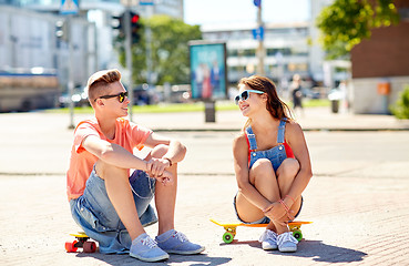 Image showing teenage couple with skateboards on city street