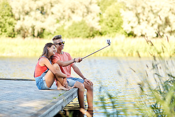 Image showing happy teenage couple taking selfie on smartphone