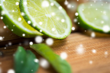 Image showing close up of lime slices on wooden table