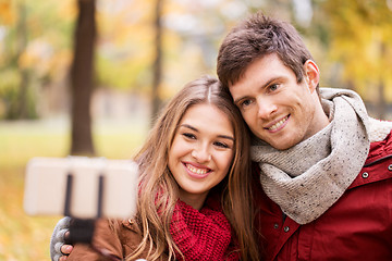 Image showing couple taking selfie by smartphone in autumn park