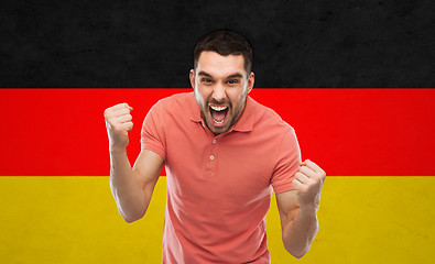 Image showing angry man showing fists over german flag