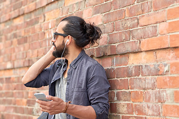 Image showing man with earphones and smartphone on street