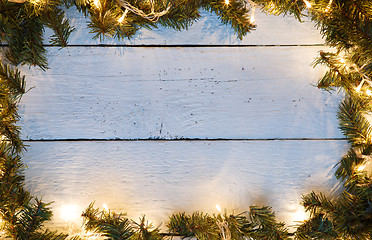 Image showing Christmas wood background with luminous garland and pine branches