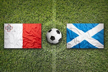 Image showing Malta vs. Scotland flags on soccer field