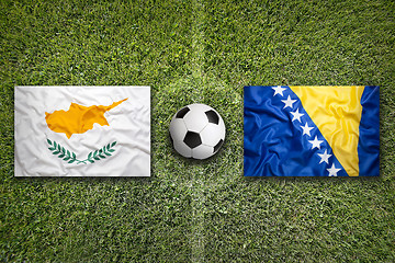 Image showing Cyprus vs. Bosnia and Herzegovina flags on soccer field