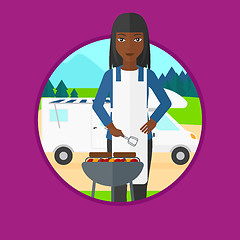 Image showing Woman having barbecue in front of camper van.