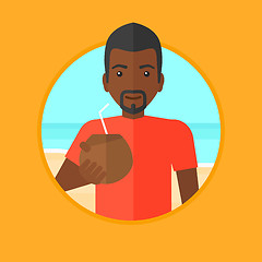 Image showing Man drinking coconut cocktail on the beach.