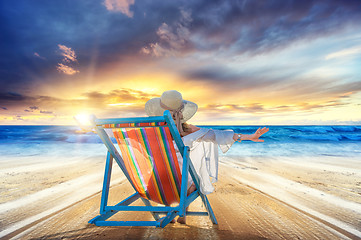 Image showing Woman in chaise-lounge relaxing at sunset 