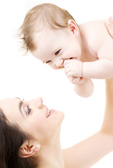 Image showing laughing blue-eyed baby playing with mom