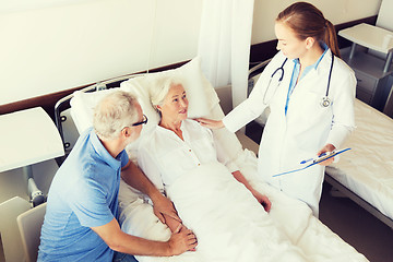 Image showing senior woman and doctor with clipboard at hospital