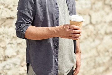 Image showing close up of man with paper coffee cup on street