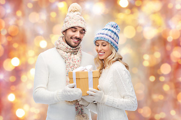 Image showing smiling couple in winter clothes with gift box