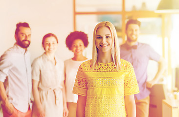 Image showing happy young woman over creative team in office