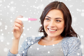 Image showing happy woman looking at home pregnancy test