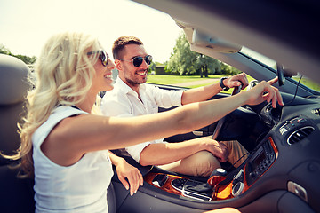 Image showing happy couple using gps navigator in cabriolet car