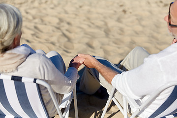 Image showing senior couple sitting on chairs at summer beach