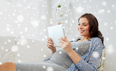 Image showing happy pregnant woman with tablet pc at home