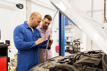 Image showing auto mechanic with clipboard and man at car shop