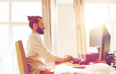 Image showing happy creative male office worker with computer