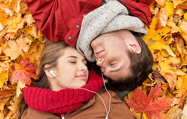 Image showing close up of smiling couple lying in autumn park