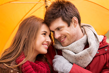 Image showing smiling couple with umbrella in autumn park